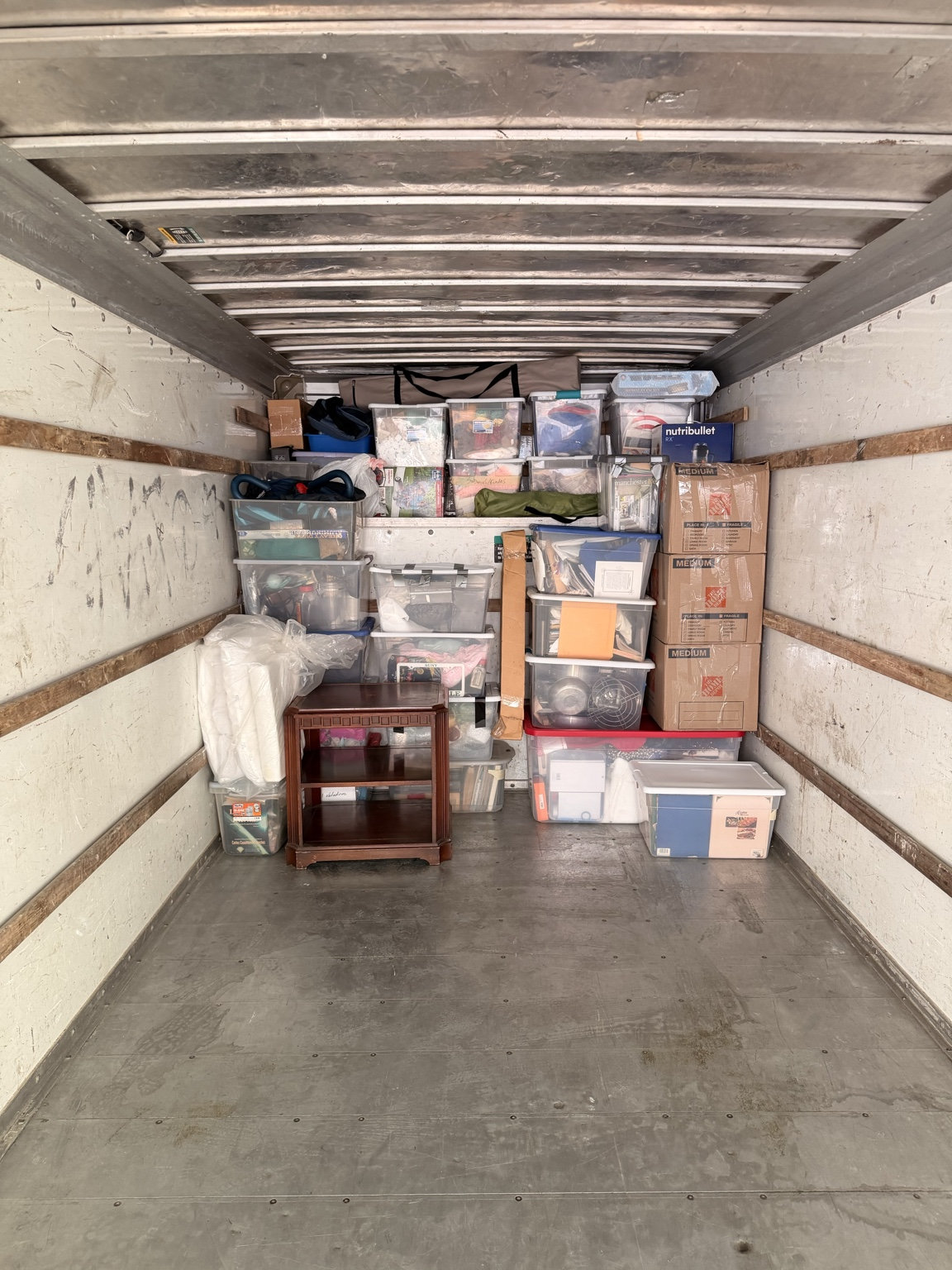 Loaded moving truck with boxes and storage bins
