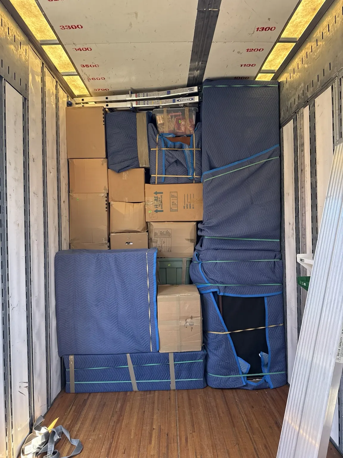 Household furniture and boxes carefully wrapped and secured inside a moving truck