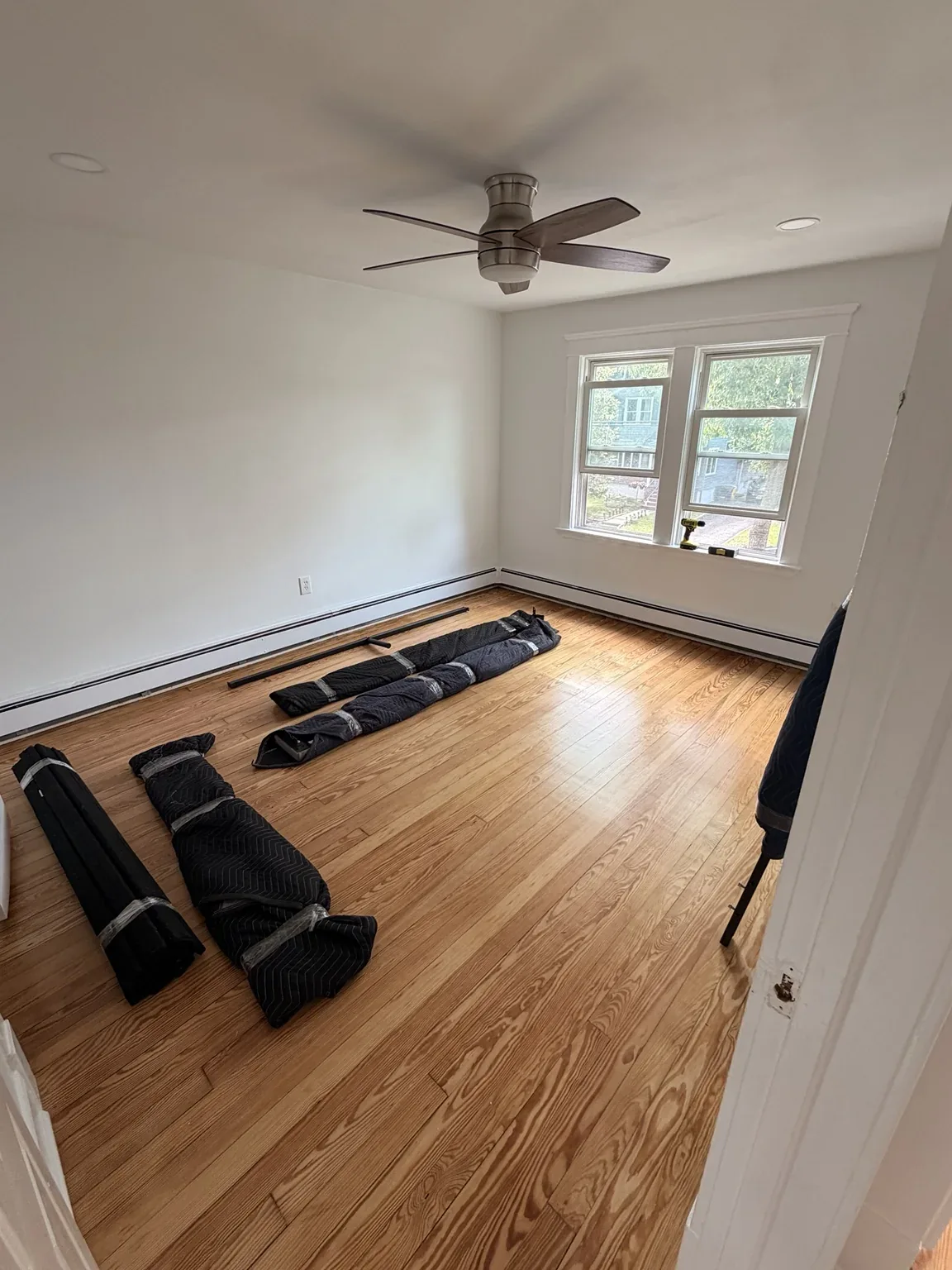 Residential room prepared for moving with protective blankets and disassembled pieces