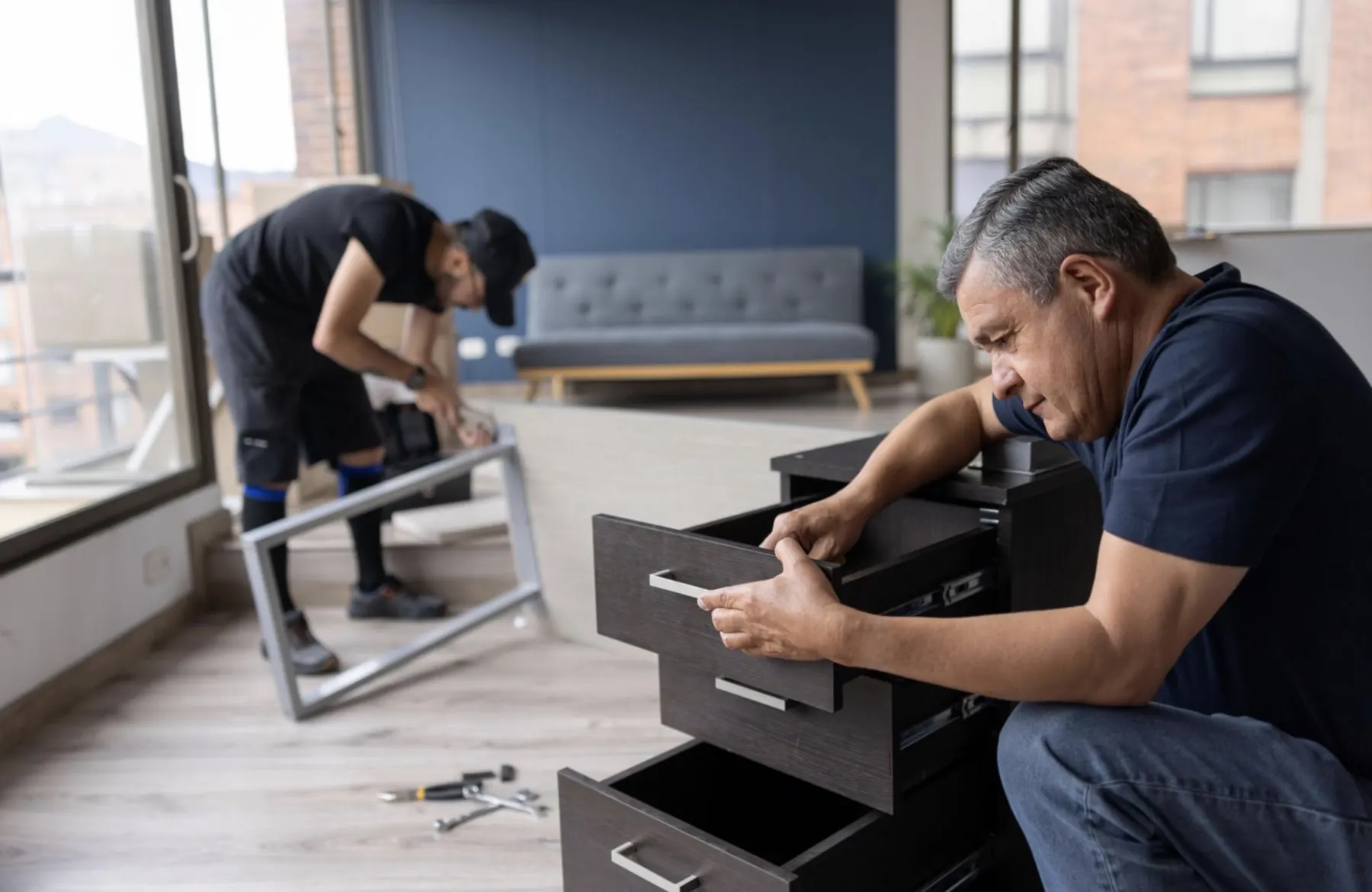 Movers inspecting and assembling furniture before moving day