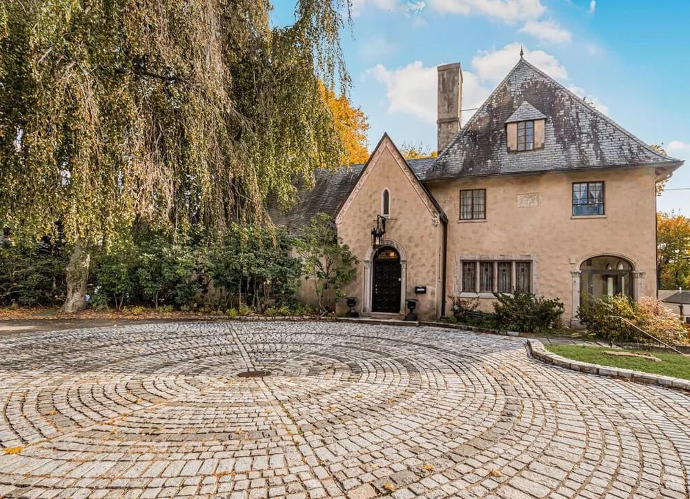 Residential house with cobblestone driveway and mature trees in Quaker Ridge